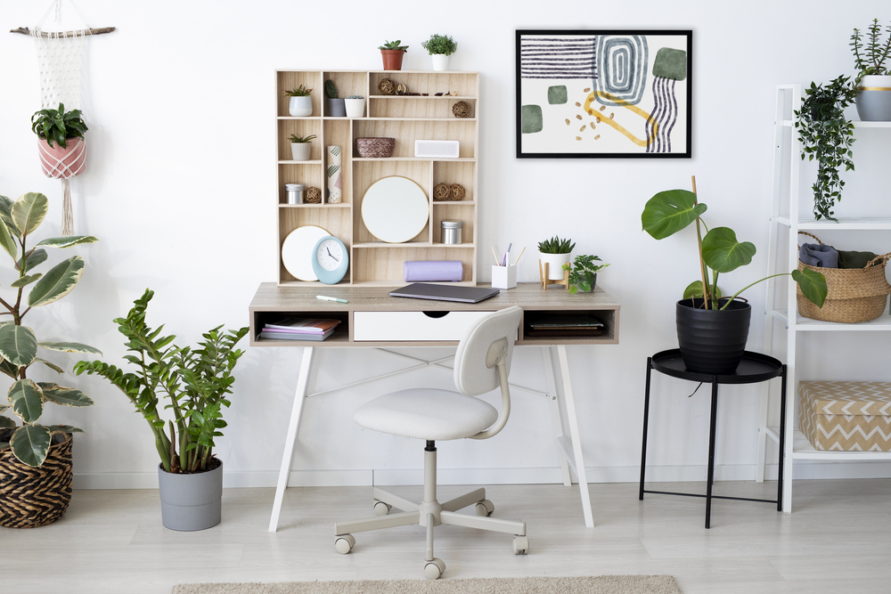 Vista de un escritorio con estantería en un ambiente luminoso, ideal para un área de estudio. La decoración incluye plantas y elementos organizadores que aportan un toque natural y ordenado al espacio.