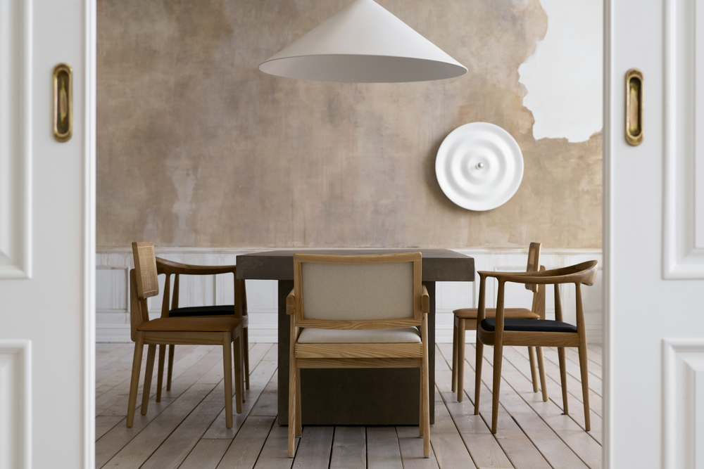 Este comedor incorpora elementos del estilo nórdico, como muebles de madera natural y una paleta de colores neutros, combinados con una iluminación sencilla y texturas suaves para maximizar la luz y el confort, reflejando simplicidad y elegancia moderna.