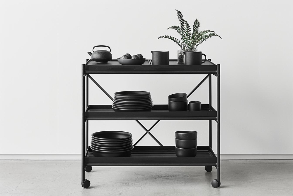 Esta estantería negra sobre ruedas demuestra funcionalidad y estilo con su construcción robusta y estética minimalista, perfecta para almacenar y organizar utensilios de cocina mientras añade un toque moderno al espacio.