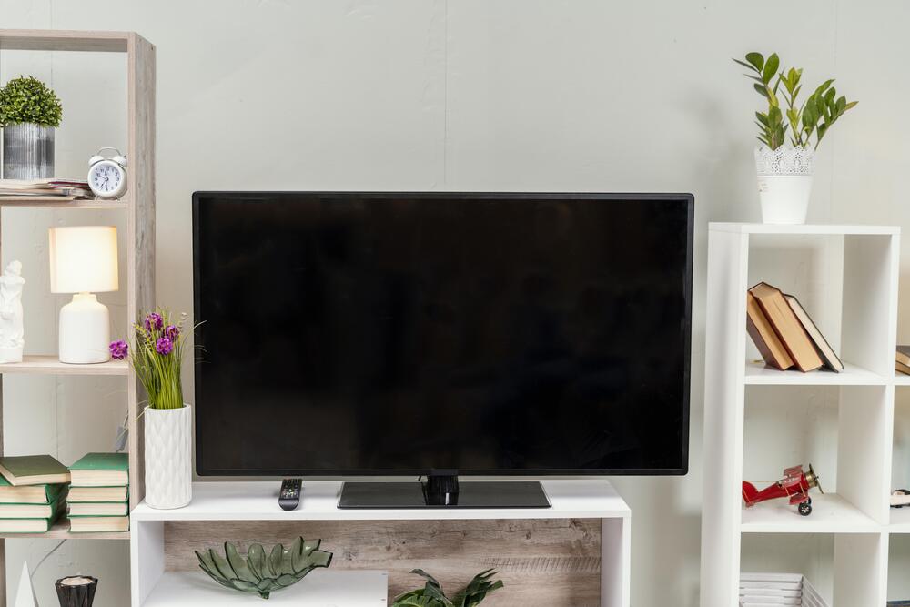 Vista de un televisor en una estantería moderna, que muestra un ambiente bien decorado y funcional, ideal para disfrutar de una experiencia de visualización cómoda.