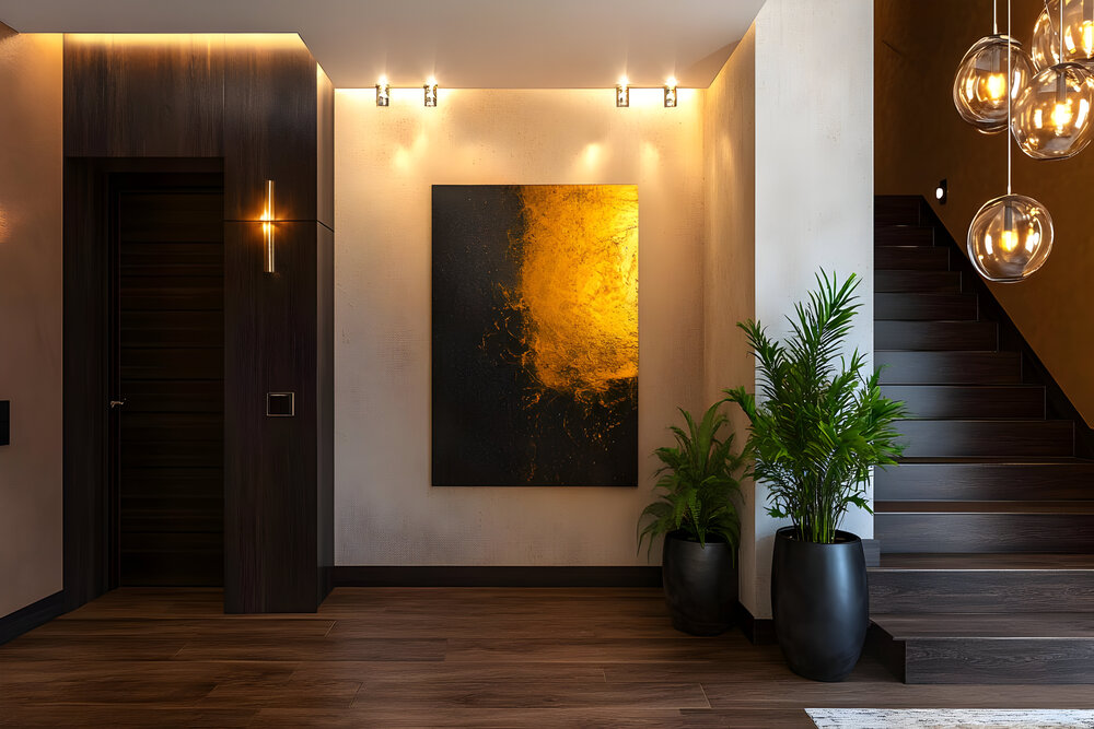 Este recibidor, diseñado sin acceso a luz natural, combina elementos cálidos y modernos como una pintura abstracta, iluminación estratégica, y plantas artificiales para crear un ambiente acogedor y visualmente amplio.
