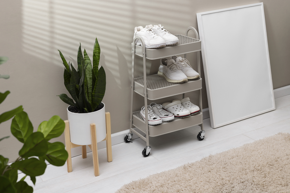 Esta estantería móvil en un entorno hogareño destaca por su diseño práctico y moderno, ofreciendo una solución de almacenamiento versátil con ruedas que facilitan la movilidad y la limpieza, ideal para mantener organizados diversos objetos como zapatos.