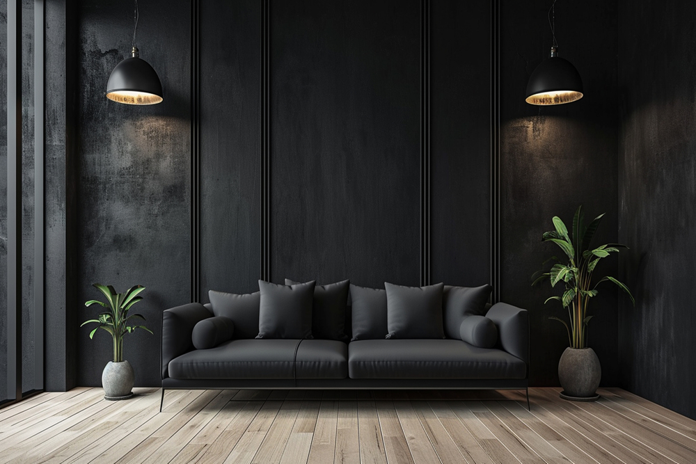 Un salón contemporáneo que destaca por su sofá negro y almohadas a juego, iluminado por lámparas colgantes. La decoración minimalista incluye plantas que aportan vida al espacio, mientras que la pared negra agrega un toque de sofisticación y elegancia.